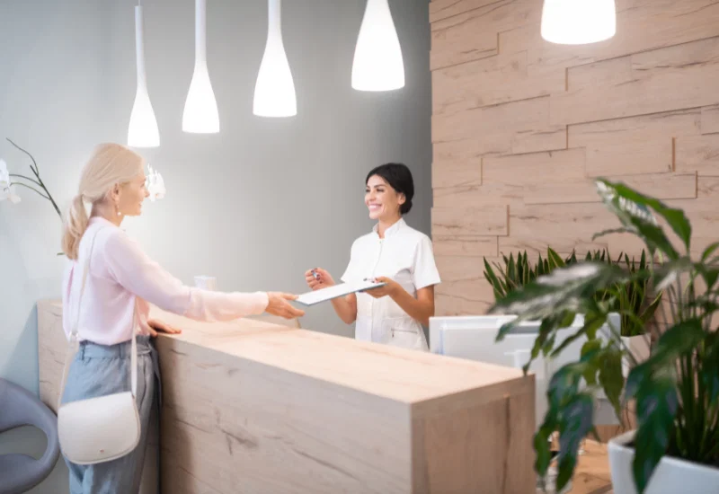 Empfangsdame übergibt NDA an einen Besucher