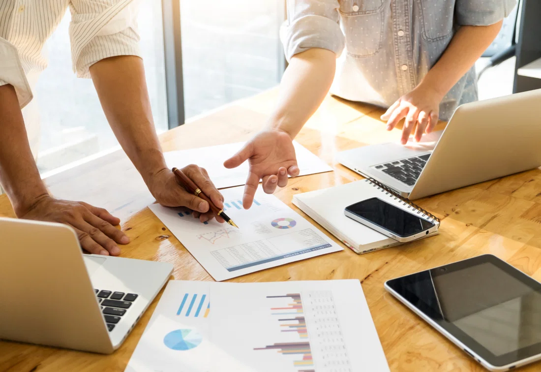 Equipo analizando cifras e informes para elaborar un caso de negocio.