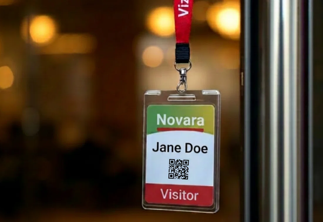 Close-up of a visitor badge showing a name, QR code, and visitor label.
